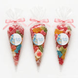 Three clear plastic sweet cones tied with pink ribbons filled with animal gummies for moses basket christening gifts