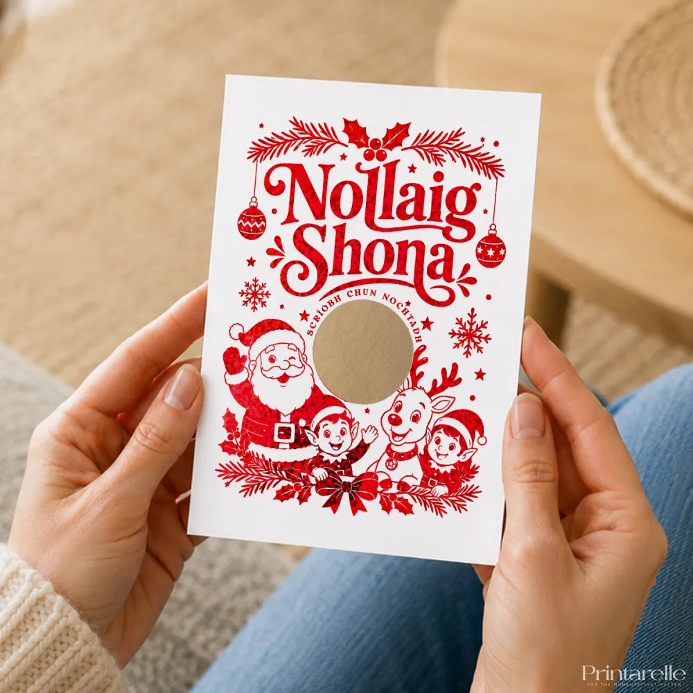 A festive white nollaig shona card with red foil holiday illustrations in irish language and a circular cutout