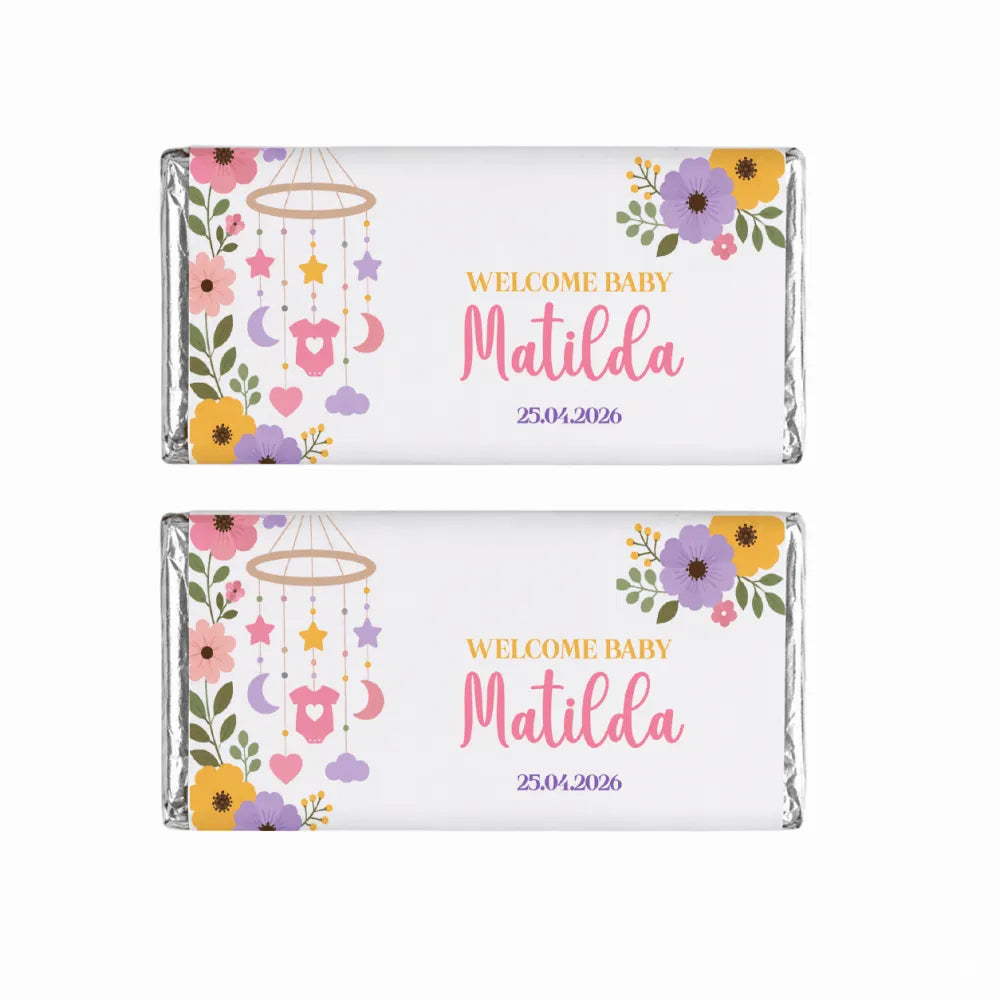 Two 40g chocolate bars with white wrappers and colorful floral designs welcome baby matilda nursery mobile gift