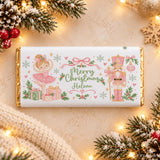 A personalized white chocolate bar with gold foil edges featuring a pink ballet dancer, soldier nutcracker, and merry christmas message