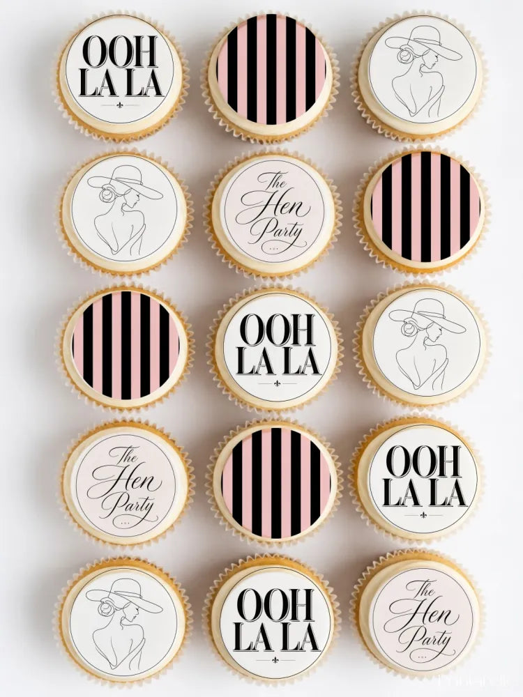 Delicate frosted cupcakes with elegant black and pink striped hen party cupcake toppers saying ooh la la and the hen party
