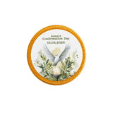 A circular gold-edged confirmation chocolate coin featuring a white watercolour dove above foliage and a candle for anna’s day
