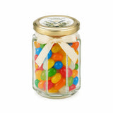 A clear glass hex jar favour with a gold lid and cream bow filled with jelly beans for peaceful dove confirmation