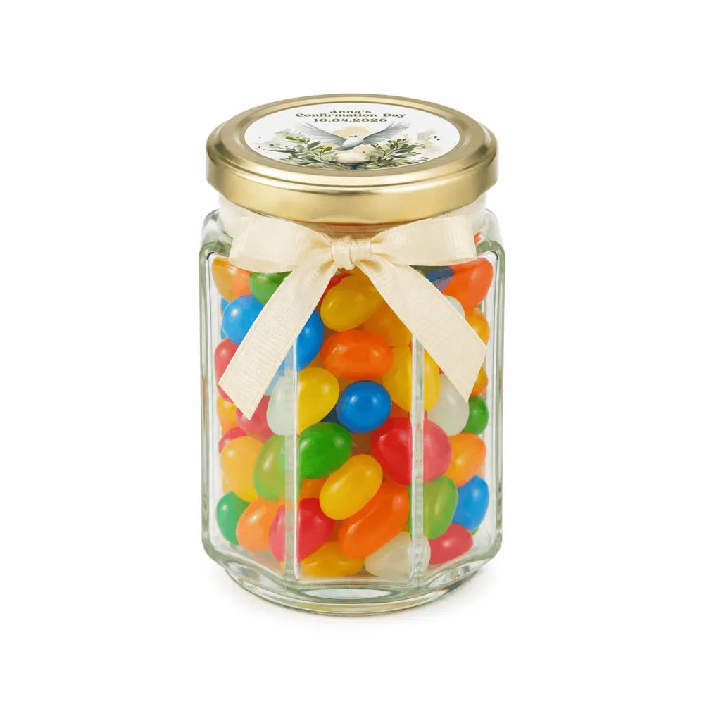 A clear glass hex jar favour with a gold lid and cream bow filled with jelly beans for peaceful dove confirmation