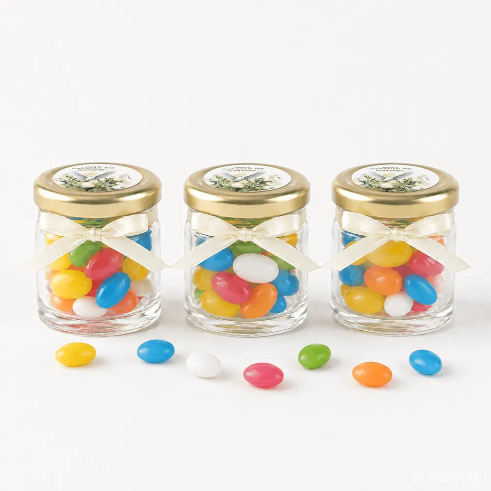 Three personalised mini jars filled with colorful jelly beans with pale gold twist lids and cream ribbons for peaceful dove confirmation