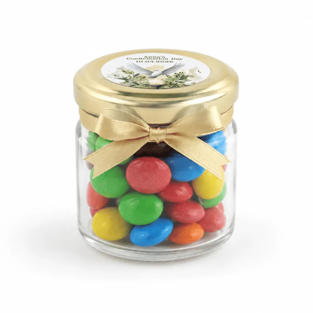 A clear glass mini jar with a 43mm pale gold lid and bow filled with colorful candy for peaceful dove confirmation