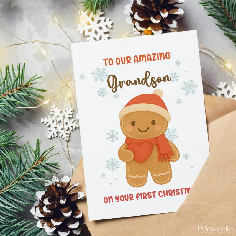 Christmas card with gingerbread man design and text 'To our amazing grandson on your first Christmas' surrounded by festive decorations.