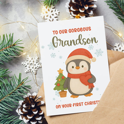 Christmas card with a penguin illustration and text for a grandson, surrounded by festive decorations.