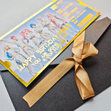Greeting card with a gold ribbon on a gray surface