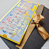 Gift card with colorful design and gold ribbon on a gray surface