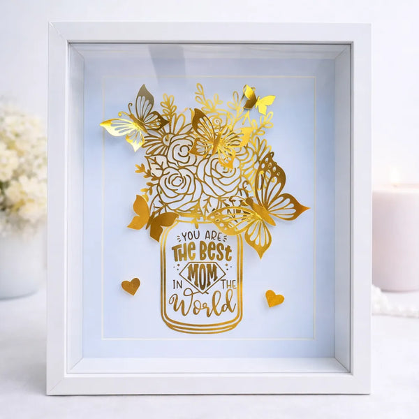 Gold laser-cut paper roses and butterflies in a mason jar design with a you are the best mom message in a white shadow box frame