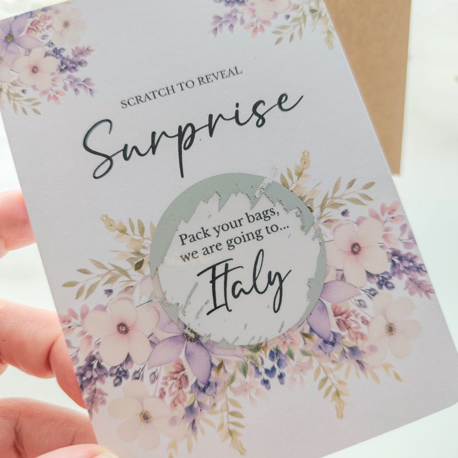 Personalised scratch-to-reveal surprise card with floral design and hidden message for travel, pregnancy, or proposal.