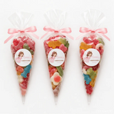 Three clear plastic sweet cones filled with colorful gummies tied with pink angel ribbons for christening sweet gifts