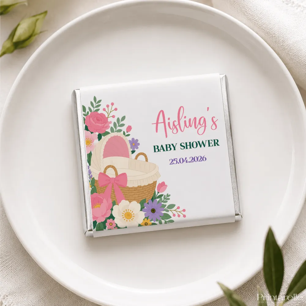 A personalized white chocolate bar with floral and baby basket design wrapped in silver foil for aisling baby shower featuring mini neapolitan chocolates