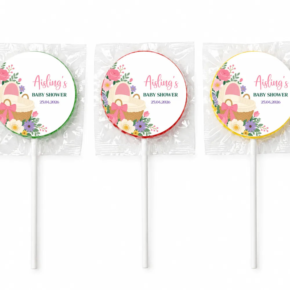 Three personalized pink bassinet baby shower swirl lollipops finished with floral cupcake basket design wrapped in cellophane