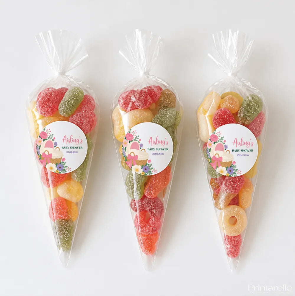 Three colorful sugar-coated gummy sweet cones in clear plastic bags with pink bassinet baby shower labels