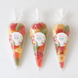 Three clear plastic sweet cones filled with colorful gummy candies for pink church communion celebrations