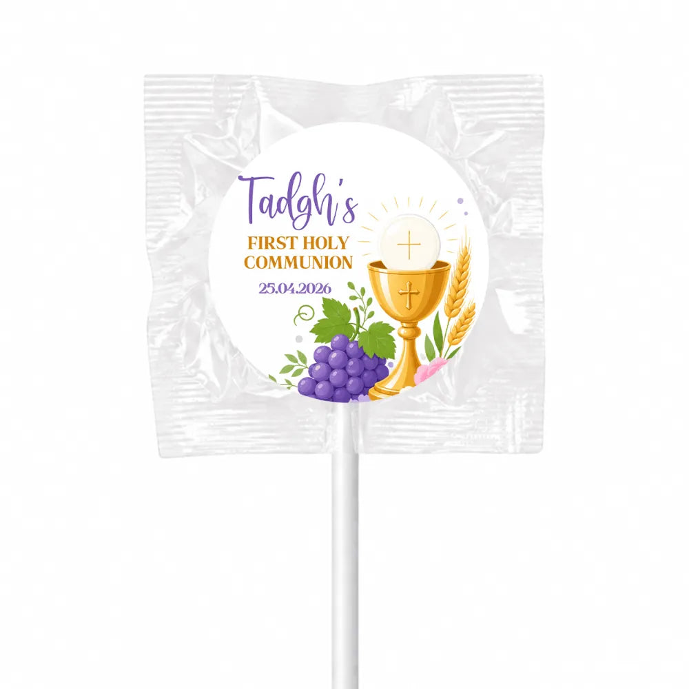 A white wrapped fruit lollipop favour with purple and gold text and a golden chalice for first holy communion