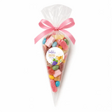 A clear plastic cone filled with colorful candies and tied with a pink ribbon personalized for tadghs first holy communion sweet cones