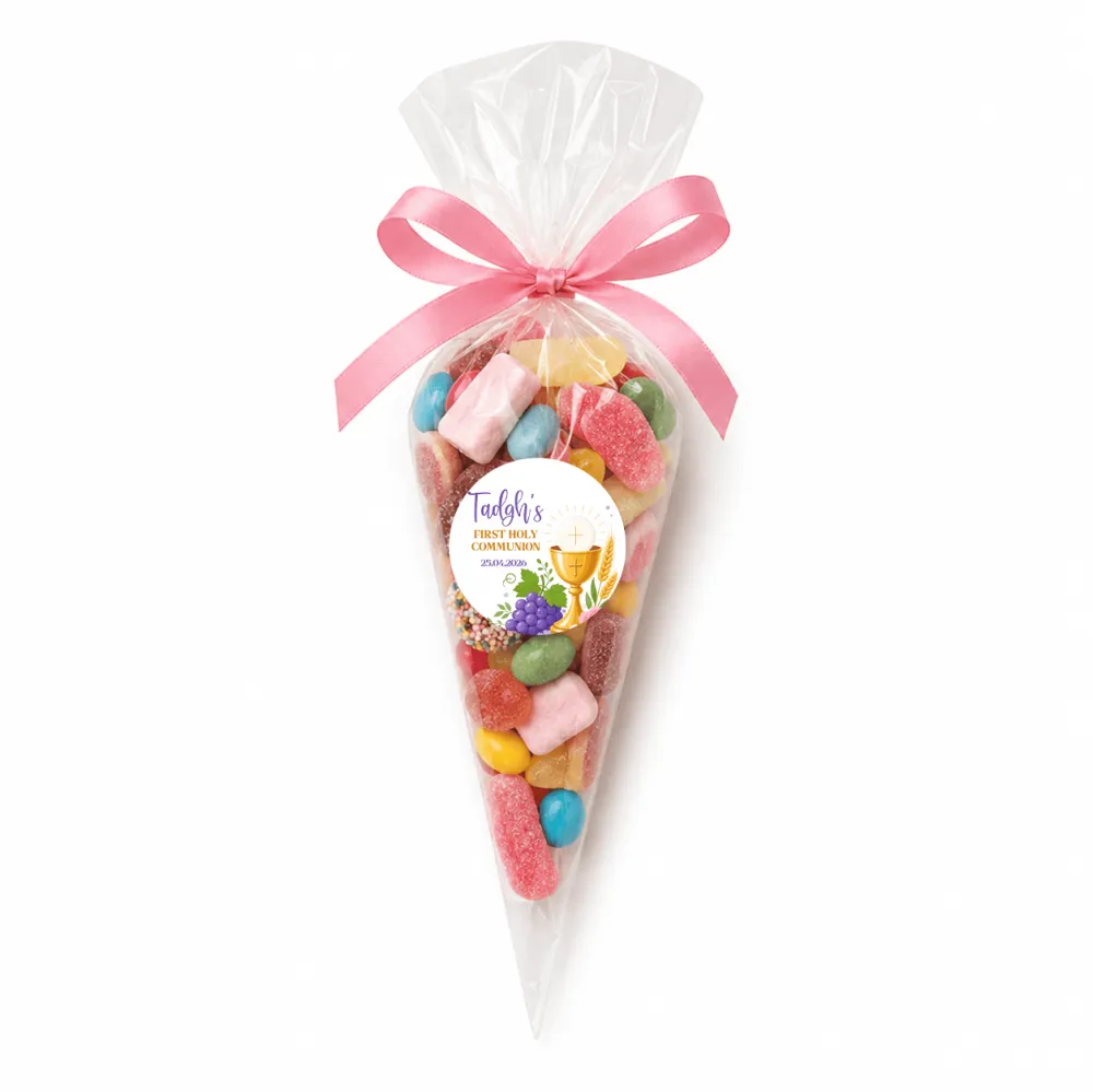 A clear plastic cone filled with colorful candies and tied with a pink ribbon personalized for tadghs first holy communion sweet cones