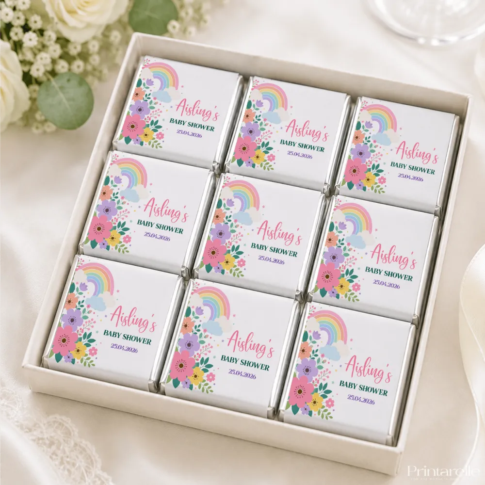Nine mini neapolitan chocolates individually wrapped in white paper with rainbow and floral designs for baby showers