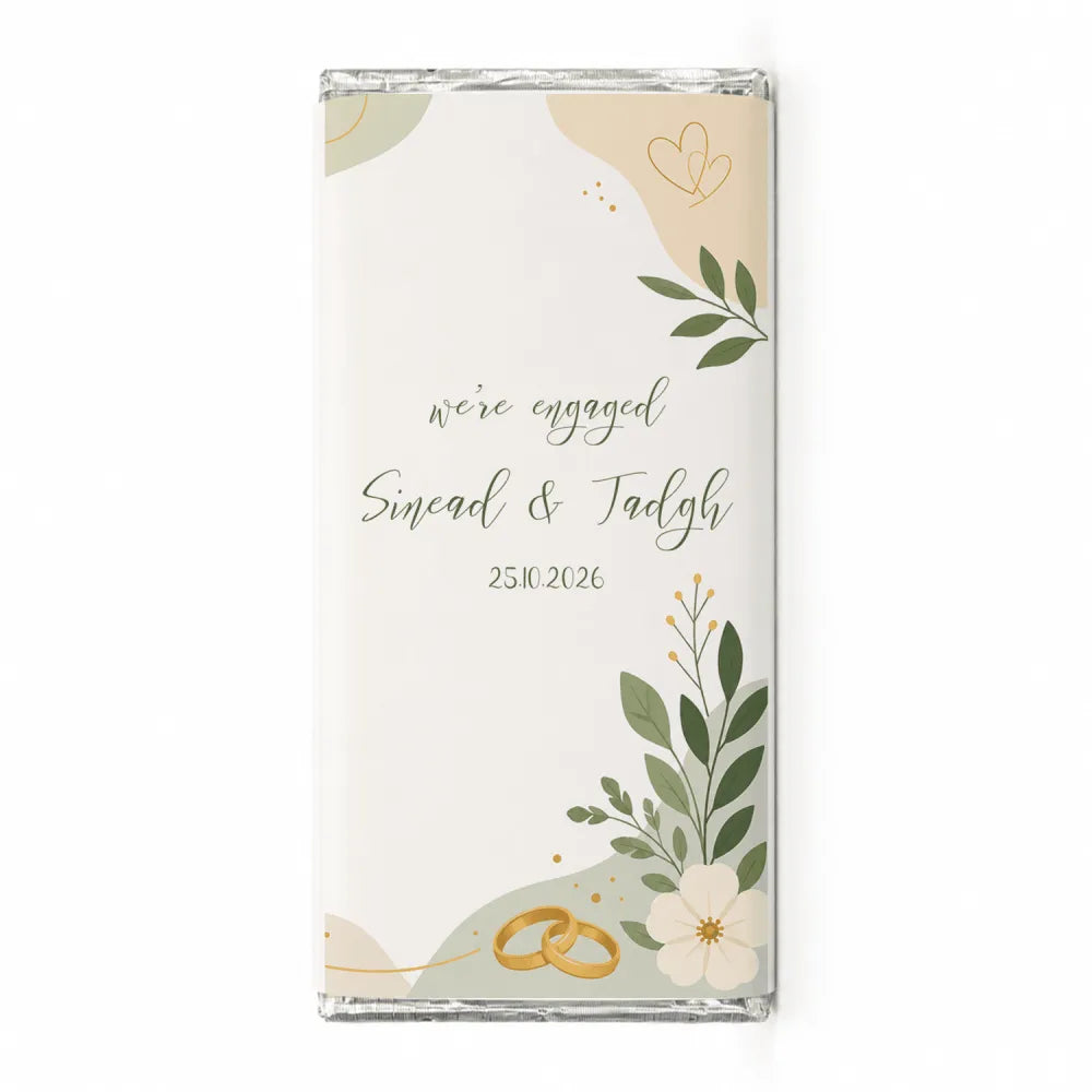 A personalised 40g white chocolate bar with floral gold design saying were engaged for sinead and tadhg october 25 2026