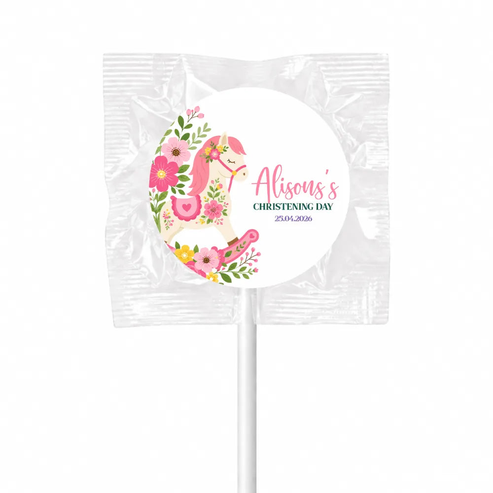 A pink floral rocking horse swirl lollipop wrapped in clear foil perfect for rocking horse lollipop favours at christenings
