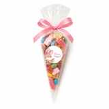 A clear plastic sweet cone filled with colorful gummies tied with a pink ribbon for rocking horse christening gifts