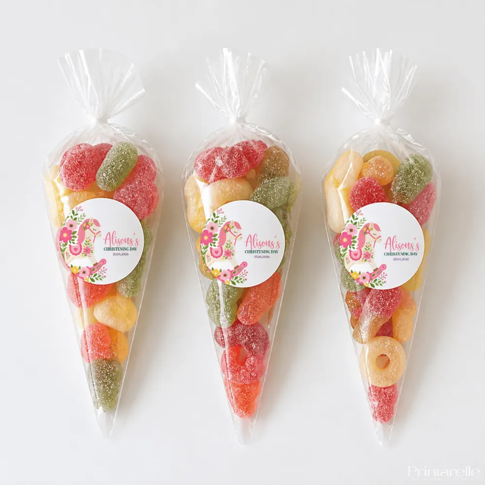 Three clear plastic sweet cones filled with colorful gummy candies for rocking horse christening gifts