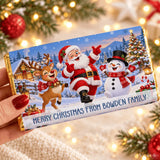 A festive chocolate bar wrap in gold foil with santa, a reindeer, and snowman for family christmas fun
