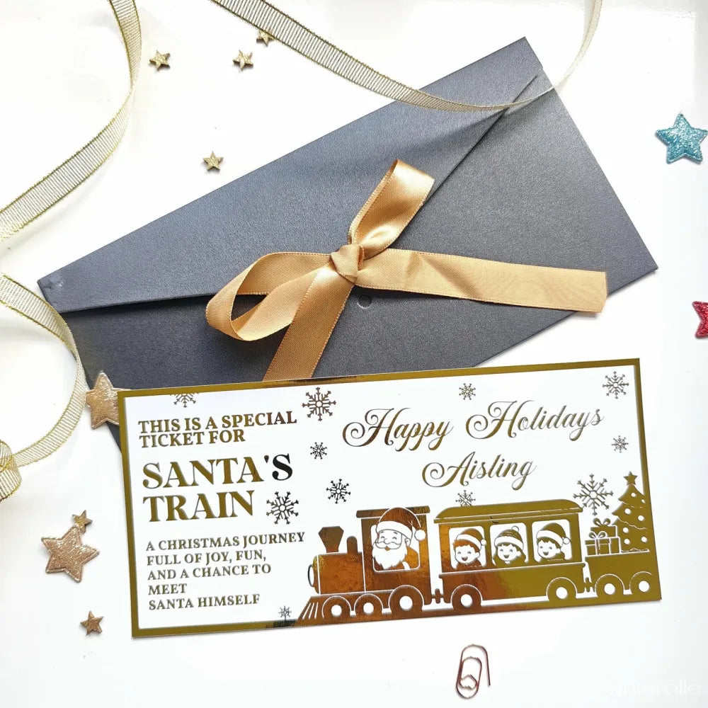 Gold foil santa train keepsake card with festive snowflakes and children on board for christmas surprise reveal