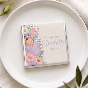 A personalized mini neapolitan chocolate bar wrapped in silver foil with a sleeping baby and floral design