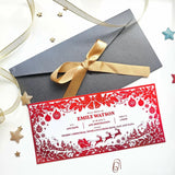 Red christmas holiday reveal card with intricate sleigh, ornament, and tree cut-outs for festive surprise reveal