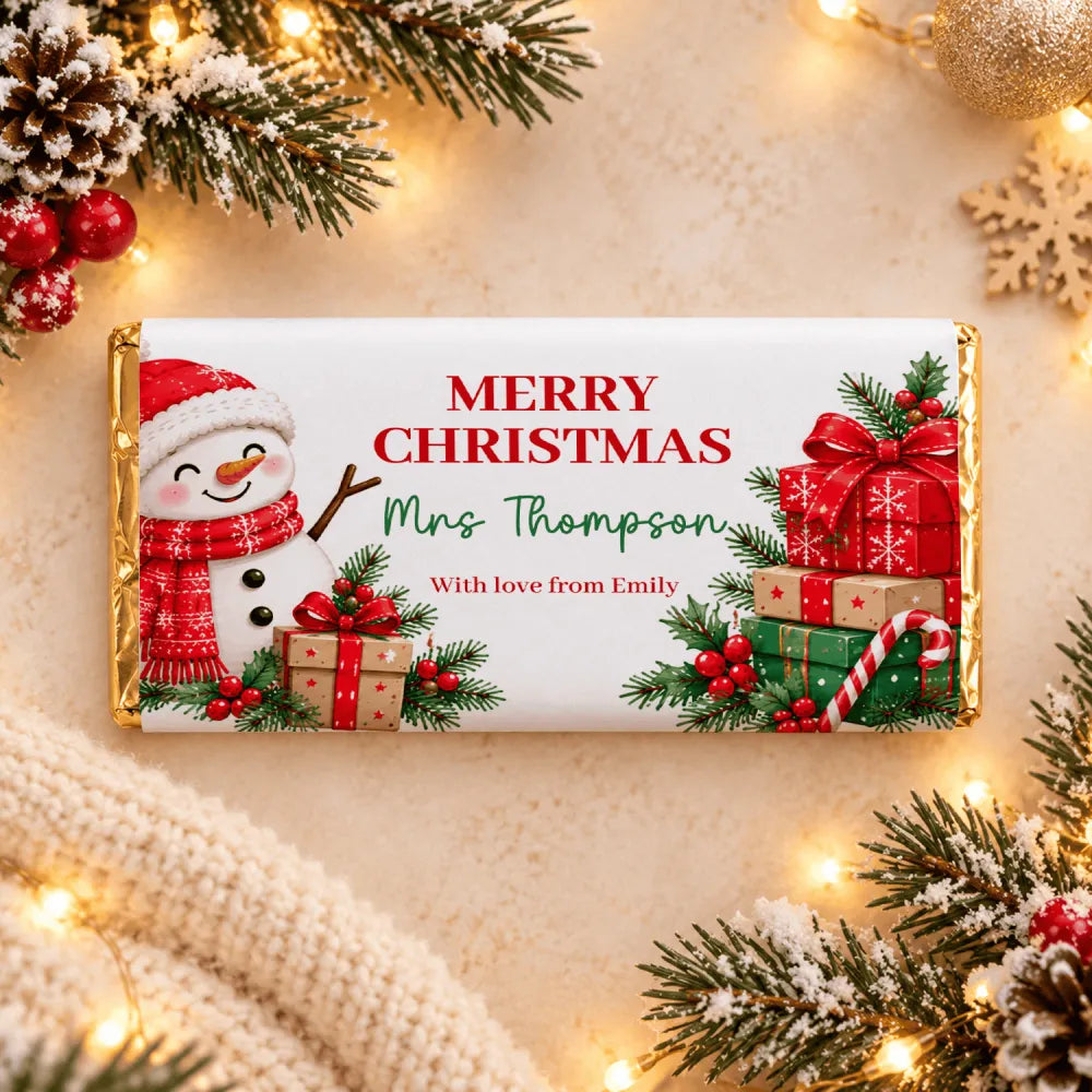 A festive white christmas chocolate bar with gold foil edges featuring a snowman and parcels chocolate bar wrap