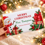 A festive white christmas chocolate bar wrapped in gold foil with a snowman and christmas gift chocolate bar wrap