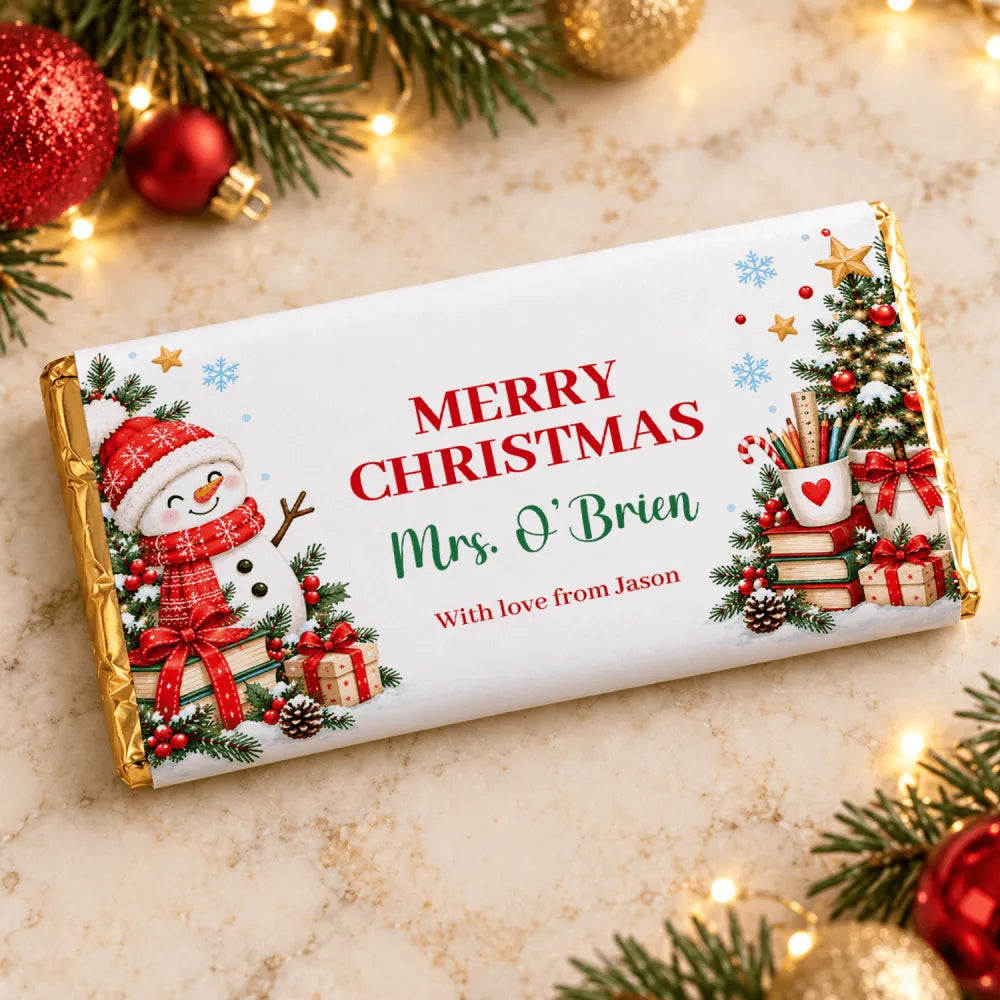 A festive white chocolate bar wrap with gold foil edges featuring a snowman and christmas tree for teacher christmas chocolate