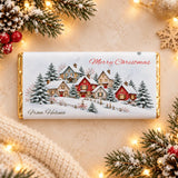 A festive gold foil wrapped personalised christmas chocolate bar with snowy cottage village design and merry christmas text