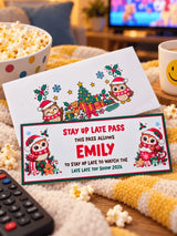 A festive white and green stay up late pass card with cartoon owls in santa hats for personalised late late toy show 2026