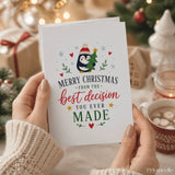 A white penguin christmas card with a red hat holding a green tree and the text merry christmas best decision