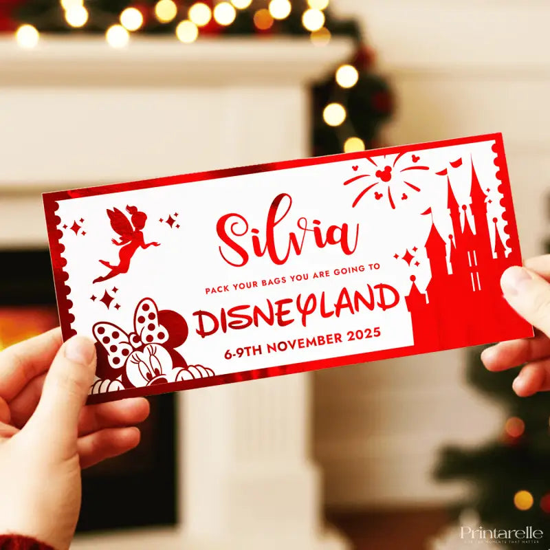 Red and white Disneyland ticket with castle and fairy design held by hands against a blurred festive background.