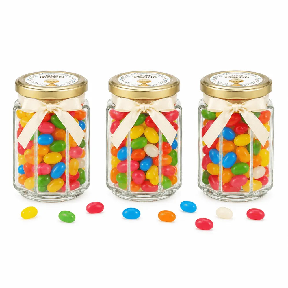 Three personalised 106ml glass jars with 48mm pale gold lids and cream bows filled with colorful jelly beans for party favours