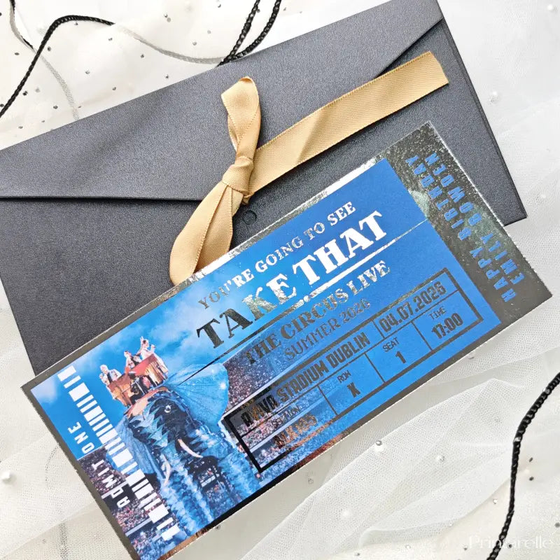 Promotional ticket for 'Take That' circus live event with a gold ribbon on a white background