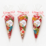 Three clear plastic sweet cones tied with pink ribbons featuring teddy bear garden labels for lauras christening day