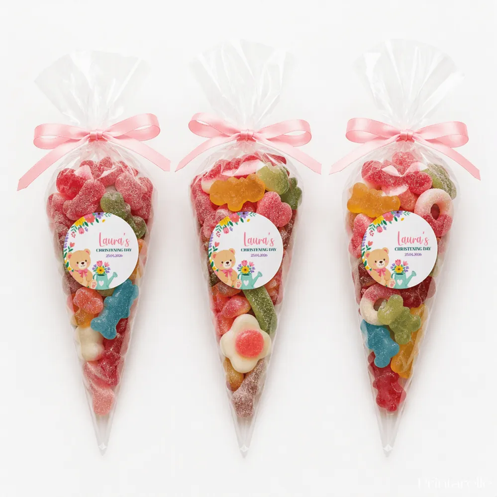 Three clear plastic sweet cones tied with pink ribbons featuring teddy bear garden labels for lauras christening day