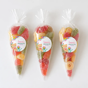 Three clear plastic sweet cones filled with colorful gummy candies for teddy bear garden christening gifts