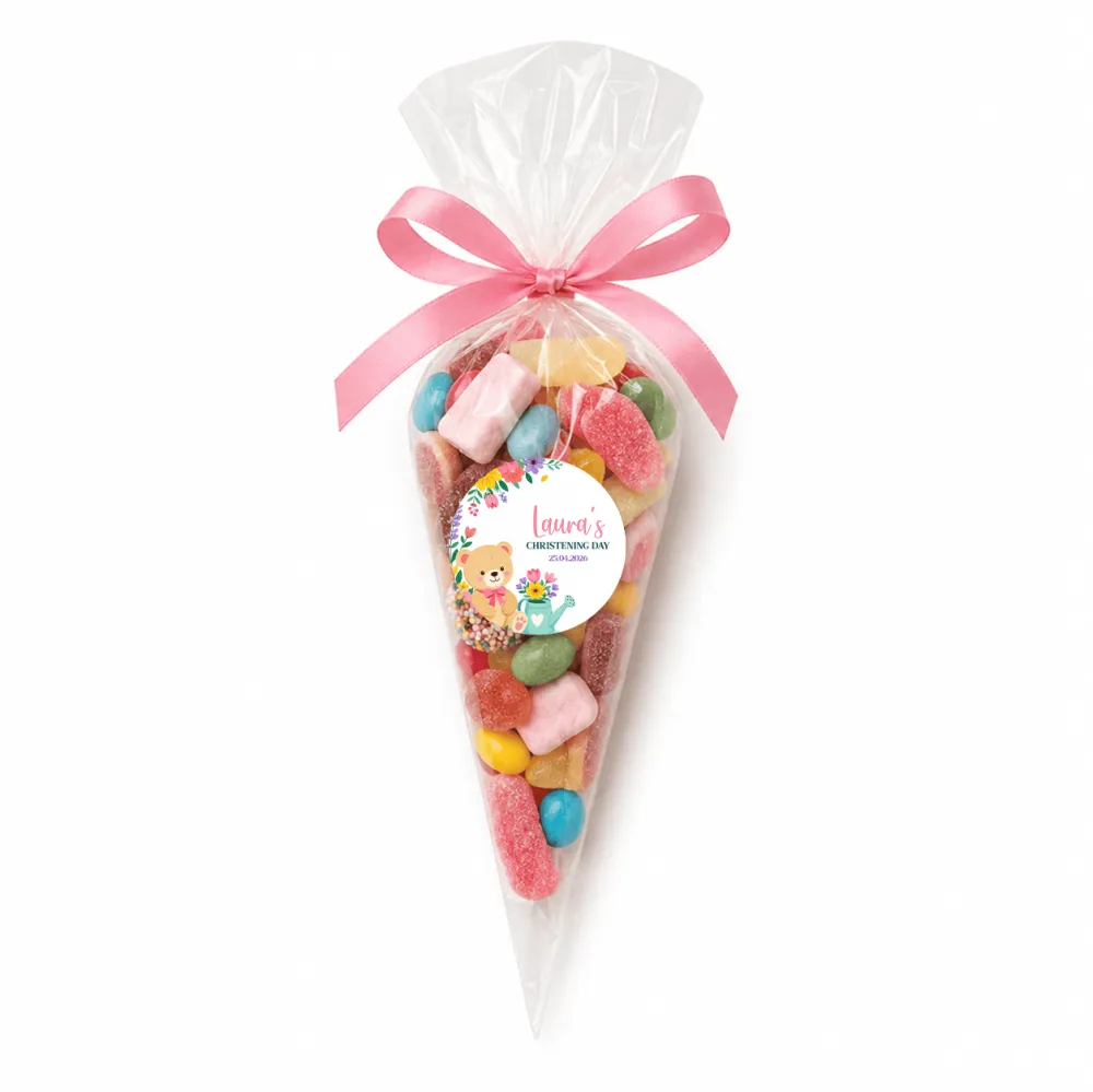 A clear plastic sweet cone filled with colorful gummies tied with a pink ribbon and a teddy bear garden label