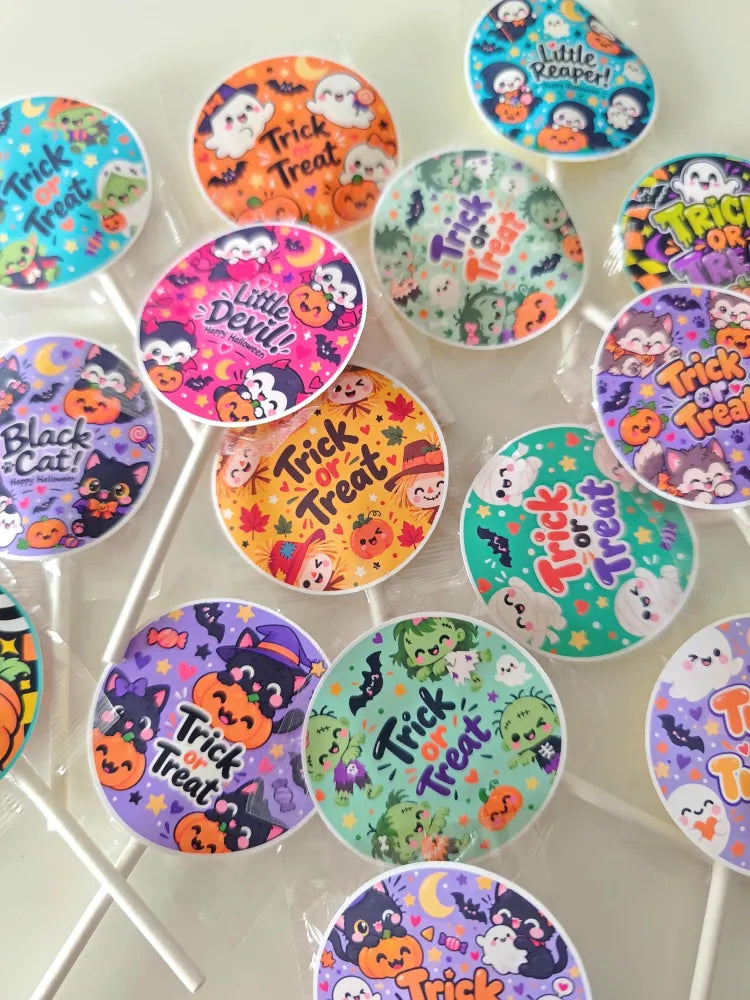 Colorful halloween-themed assorted fruit lollipops with black cat and cartoon characters on glossy wrappers