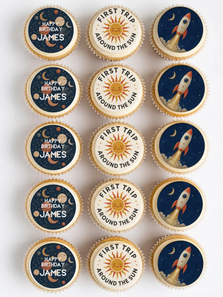 Vintage space first birthday cupcake toppers with rockets suns and planets on dark blue icing sheet for birthday cupcakes