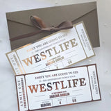 Two concert tickets for Westlife's 25th Anniversary World Tour with a brown envelope and ribbon.
