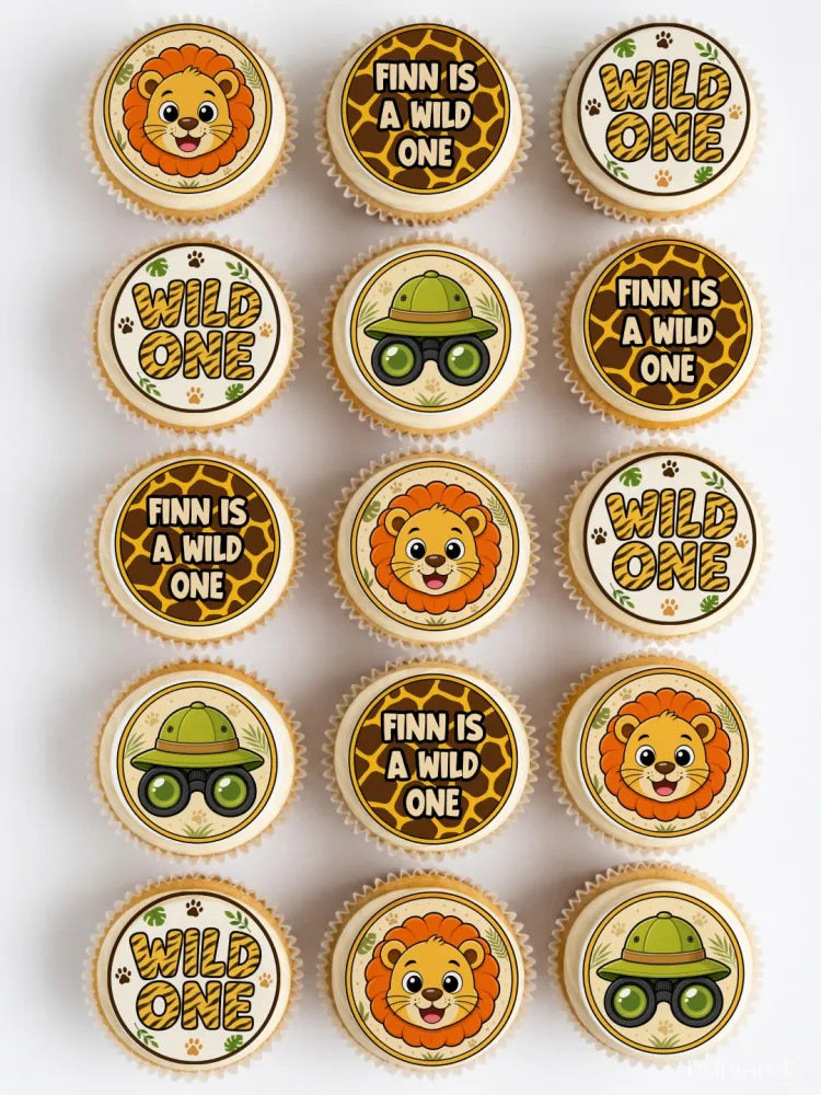 Wild one safari first birthday cupcake toppers with jungle-themed edible decorations and brown giraffe print background